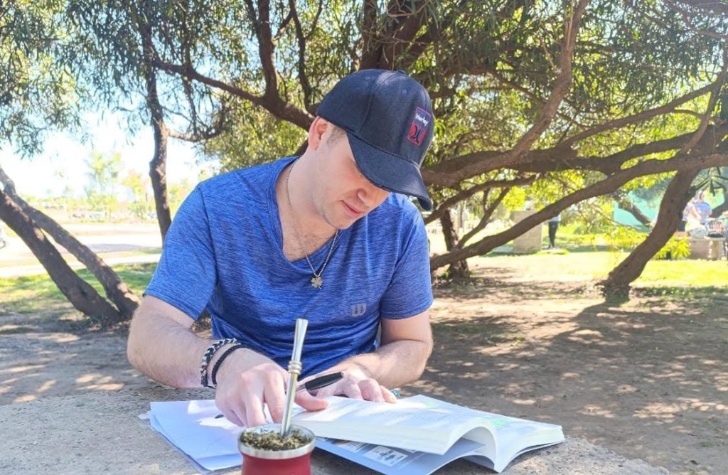 Matias Gutierrez estudiando con un libro al aire libre